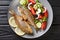 Fried Salema porgy sea fish with fresh vegetable salad close-up on a plate on the table. Horizontal top view