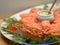 Fried salmon fillet arranged on a plate with dill, slices of smoked salmon, and a small china dish with mustard sauce