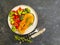 Fried salmon slice on a plate, tomato on concrete background