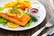 Fried salmon steak, French fries and fresh vegetable salad served on wooden table