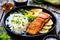 Fried salmon steak with lemon, jasmine rice and fried pak choi cabbage served on wooden table