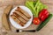 Fried sausage in plate, pepper, tomato, lettuce, bread and fork