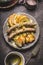 Fried sausages with baked apples, onions and lye bun toast served on rustic table with white coleslaw salad , plates and cutlery