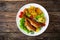 Fried sea bass with fried potatoes and fresh cabbage salad on wooden table