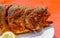 Fried and seasoned trout at a fishing festival on a white plate