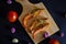 Fried shrimp served with tomatoes, shallots, garlic with cutting board on black background.