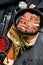 Fried sliced marble pork steak in a pan. Organic meat. Black background. Top view