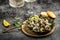 Fried snails Escargots de Bourgogne with herbs, butter, garlic on metal plate with forks, wine glass. gourmet food. Restaurant
