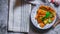 Fried Solanum melongena with Egg in a green dish on the table with garlic, dried chilli