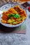 Fried Solanum melongena with Egg in a green dish on the table with garlic, dried chilli