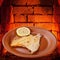 Fried sole fish on plate and hot bricks of oven