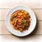 Fried spicy Thai-style seafood spaghetti on a white plate, on a wooden background