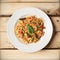 Fried spicy Thai-style seafood spaghetti on a white plate, on a wooden background