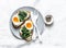 Fried spinach, labne and boiled eggs sandwiches - delicious healthy breakfast or snack on a light background