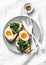 Fried spinach, labne and boiled eggs sandwiches - delicious healthy breakfast or snack on a light background