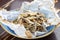 Fried sprat in parchment on wooden background