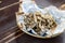 Fried sprat in parchment on wooden background