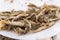 Fried sprat in white plate on white table served at a restaurant. Selective focus