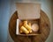 Fried spring rolls in a brown takeaway container with creamy sauce