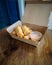 Fried spring rolls in a brown takeaway container with creamy sauce