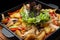 Fried stewed potatoes with vegetables and mushrooms in a cast iron pan. selective focus