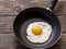 Fried sunny side up eggs on a pan on a brown old wooden board