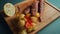 fried surmullet fish with potato and lemon on wooden board on black background