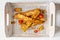 Fried tempeh in a white tray decorated with on wooden surface. Top view