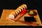 Fried tempura sushi rolls set on wooden plate on dark background. Japanese traditional fusion food style, restaurant