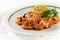 fried tiger prawns, marinated with garlic, spices, herbs and lemon on a fine white plate, italian parsley garnish, bright