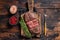 Fried Top Blade or flat iron roast beef meat steaks on wooden board with rosemary. Dark wooden background. Top View