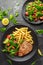 Fried Tuna Steaks on Black Plate with Fresh Green, Tomato Salad, lemon and french fries. healthy sea food