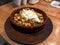 Fried Turkish manti with spices and cream in a traditional dish on a wooden tray. selective focus. small focus area