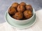 Fried vegan falafel in a mint bowl on a plate on a towel