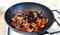 Fried vegetables: onions, carrots, peppers, decorated with black olives. Vegetable stew in a pan. The process of stewing vegetable