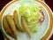 Fried whole fishes with lettuce tomato slices and mayonnaise salad sauce