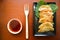 fried wonton. wonton on plate with chili oil. Shrimp or meat dumpling soup with mustard , green onions, on table