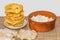The fried yellow tortillas with cottage cheese lie like a pyramid on a small white plate and a clay brown bowl with