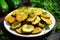 Fried zucchini slices garnished with herbs on a white plate