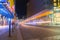 Friedrichstrasse at night illuminated by street lights and neon signs with rail tracks leading into distance