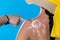 A friend lubricates her friend`s back with a sunscreen cream while doing the sun symbol