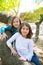 Friend sister girls resting on tree trunk nature