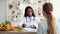 Friendly african american female nutritionist giving consultation to patient in her clinic, discussing diet diary