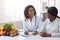 Friendly afro lady nutritionist making patient anamnesis at clinic