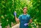 Friendly agronomist checking tomatoes in greenhouse