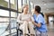 Friendly asian caregiver talking to senior resident in nursing home