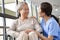 Friendly asian staff talking to senior resident in nursing home