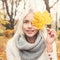 Friendly Blonde Woman Fashion Model holding Fall Leaf