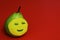 Friendly cartoon - beauty salon. Stylish happy green ripe juicy pear with yellow cosmetic mask on red background. Art idea.