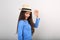 Friendly casual woman in blue top and straw hat posing and looking happy